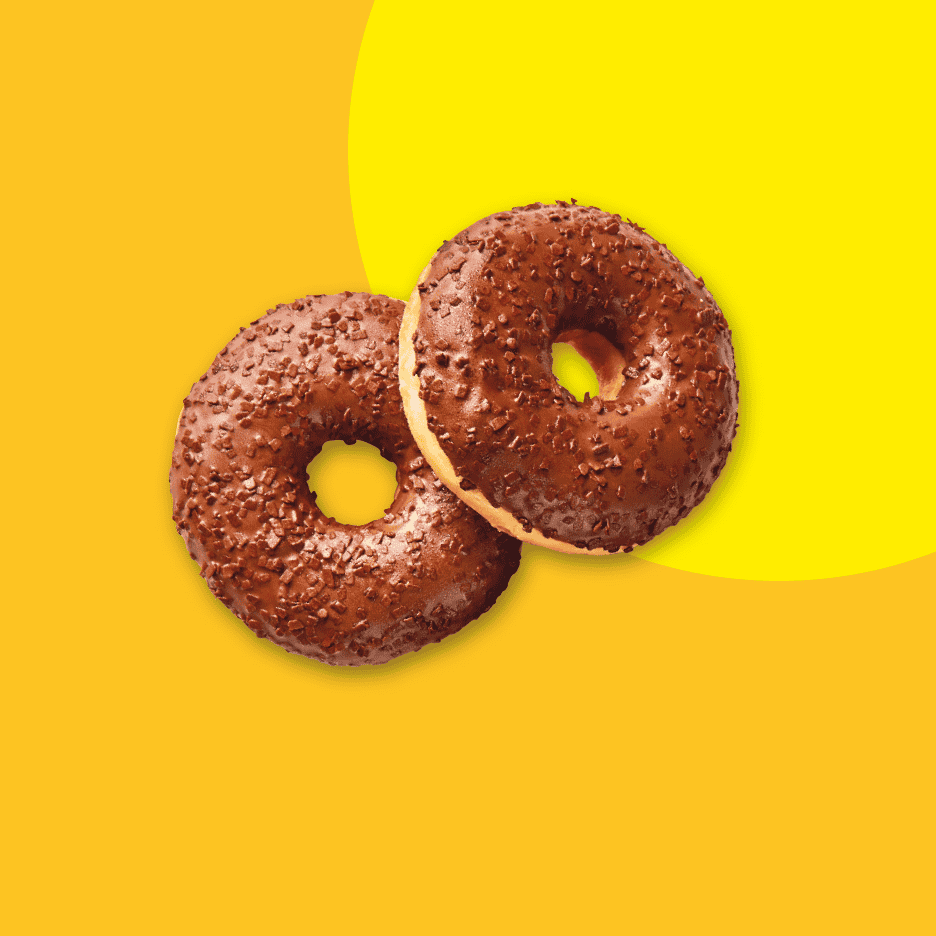 To chokoladedonuts med krymmel på en gul baggrund.