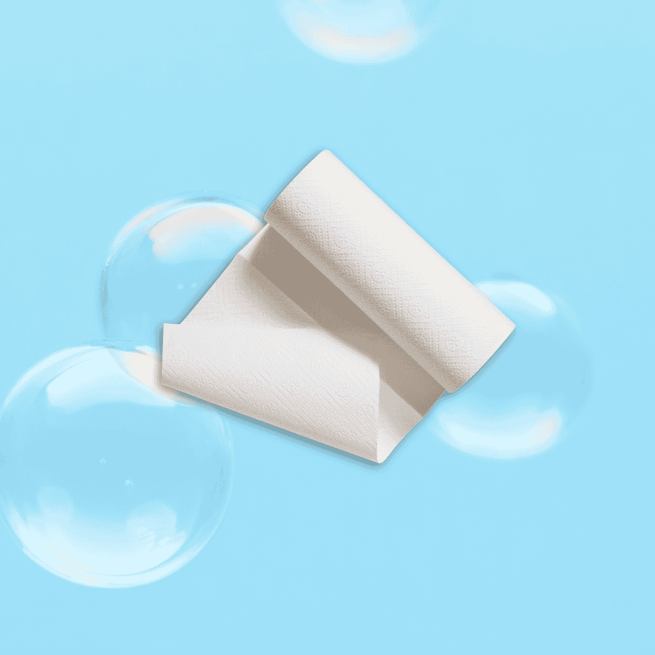 Et hvidt køkkenrulleark svæver blandt sæbebobler på en lyseblå baggrund.