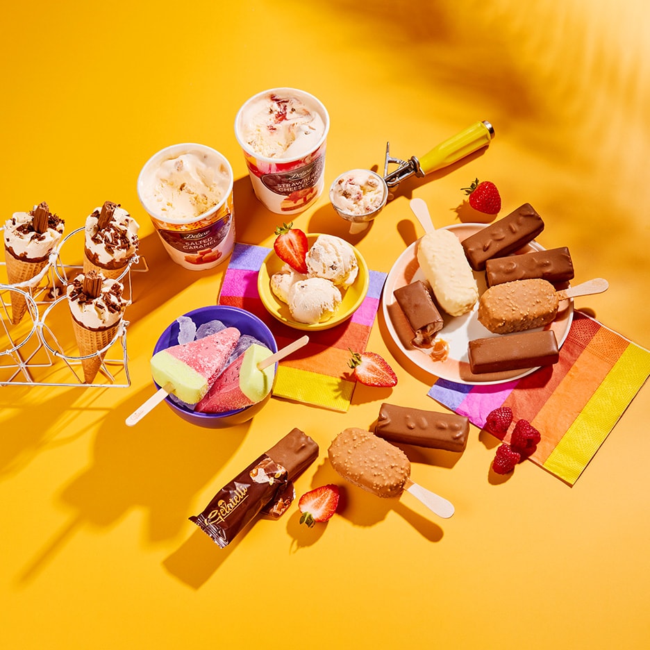 Et udvalg af isprodukter, herunder isvafler, ispinde, isbægre og en isdessert, på en gul baggrund.