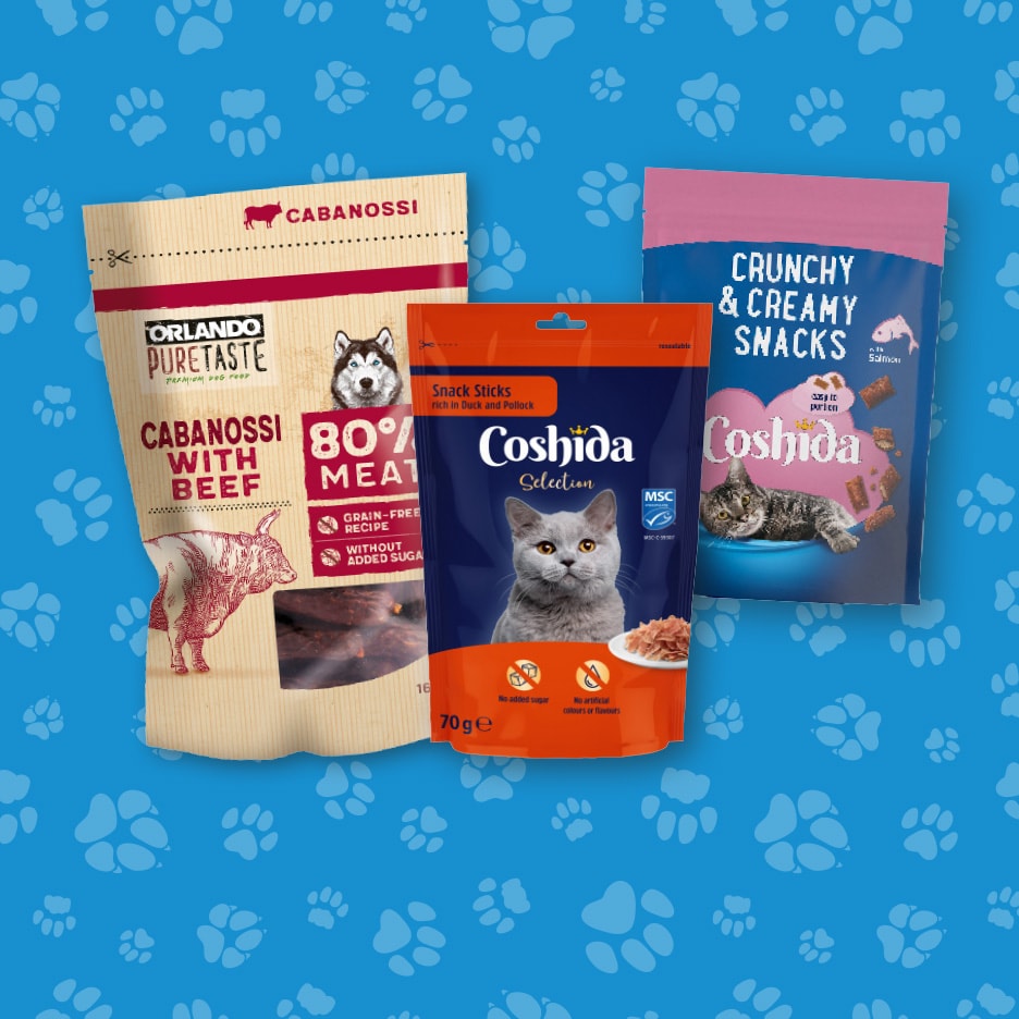 Tre pakker med hundesnacks og kattemad, herunder kødfulde cabanossi og sprøde snacks, på en blå baggrund med potespor.