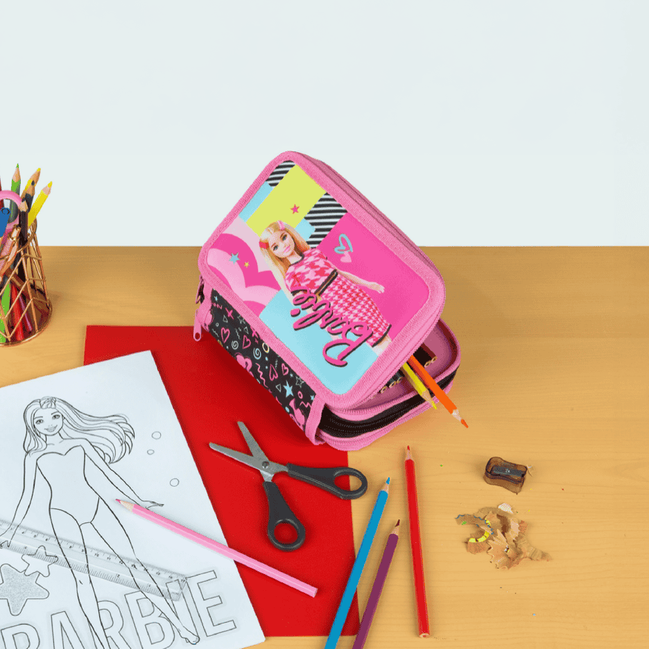 Penalhus med tegning af en pige, farveblyanter, saks og tegneblok på et træbord.