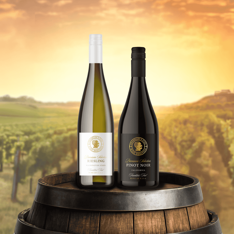 To vinflasker, en Riesling og en Pinot Noir, på en vintønde i en vingård ved solnedgang.