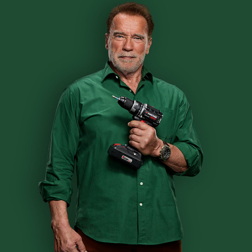Arnold Schwarzenegger holder en Parkside boremaskine.